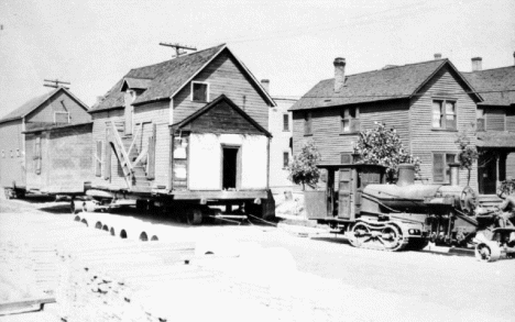 Two houses being moved from North Hibbing by Cleveland tractor, 1921