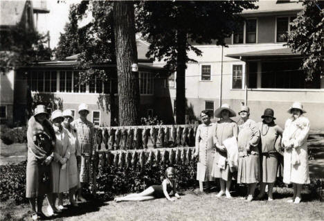 Ladies posing with fish and child, Blake Hotel, Alexandria Minnesota, 1907