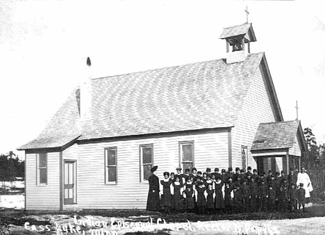Rector and pupils in front of Cass Lake Indian Episcopal Chapel, 1895