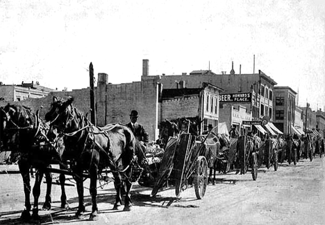 Farmers with farm machinery bought from N. P. Stone Company on Main Street, Crookston Minnesota, 1890