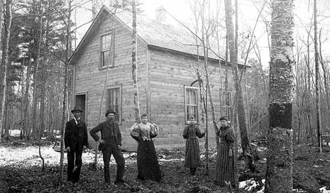 People posed in front of house provided by the Red Cross to Hinckley fire victims