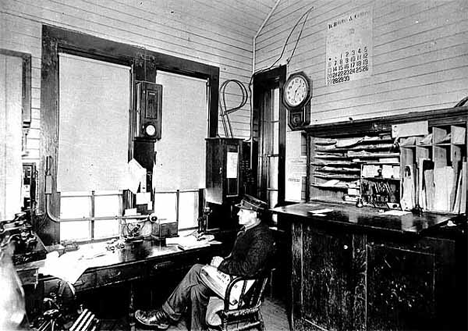 Depot agent Harry Ellis in depot at Solway Minnesota, 1910