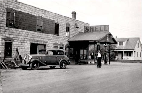 Al Bailey standing in front of the Shell station, Tenstrike Minnesota, 1930