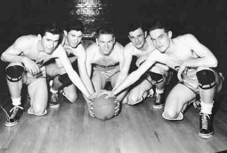 The 1942 Minnesota State Basketball Champions from Buhl gathered around a basketball. Pecky Smilanich is second from the right.