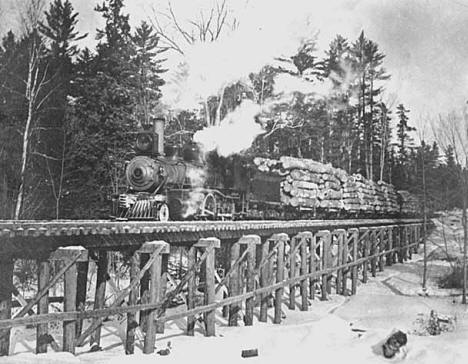 Logging train going over railway bridge at Alger Smith Lumber Company, Knife River.