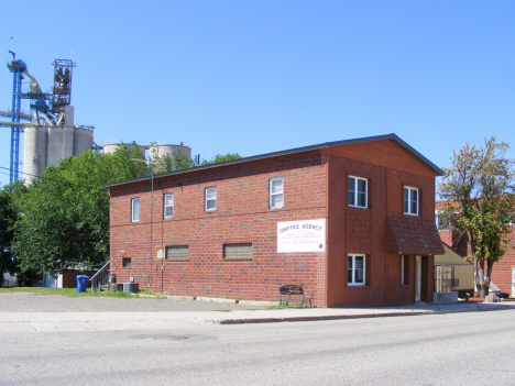 Insurance agency with elevators in background, Clarksfield Minnesota, 2014