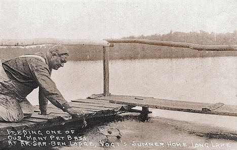 Feeding pet bass at Ak-Sar-Ben Lodge, Vogt's Summer Home on Long Lake, Aitkin Minnesota, 1930's