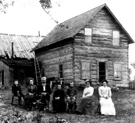 Potts family is sitting in front of the first building in the Wahkon Minnesota area, 1902